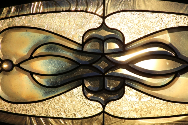 Artistic glass patterns on the front window of my parent's house, backlit by the setting sun.